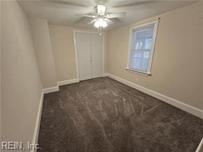 unfurnished bedroom with dark colored carpet and ceiling fan