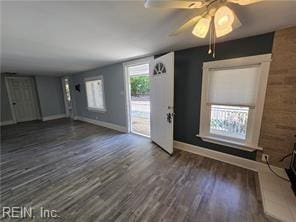 unfurnished living room featuring dark hardwood / wood-style flooring and ceiling fan