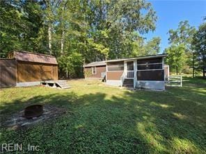 view of yard with a storage shed and a sunroom