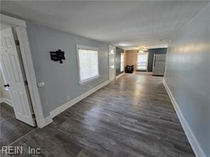 hall featuring a wealth of natural light and dark hardwood / wood-style flooring