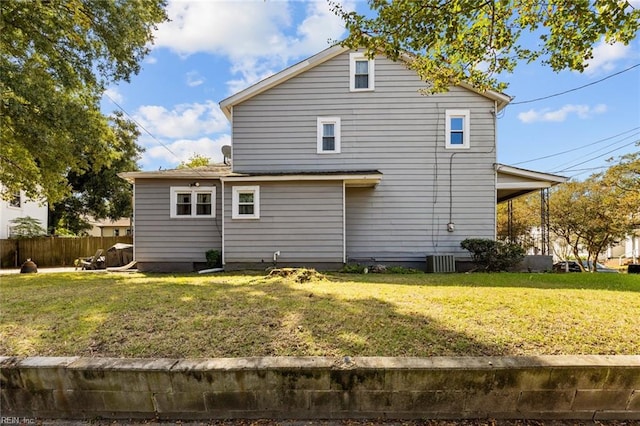 rear view of property featuring a lawn