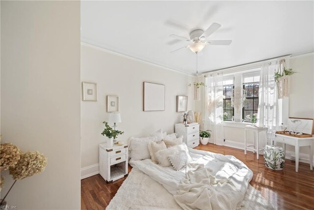 bedroom with dark hardwood / wood-style flooring, ceiling fan, and crown molding