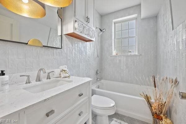 full bathroom featuring tasteful backsplash, tile walls, vanity, bathtub / shower combination, and toilet