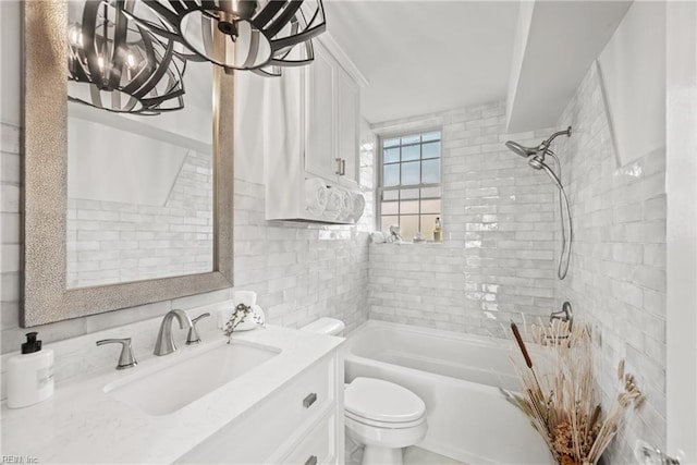 full bathroom featuring toilet, tiled shower / bath combo, vanity, and decorative backsplash