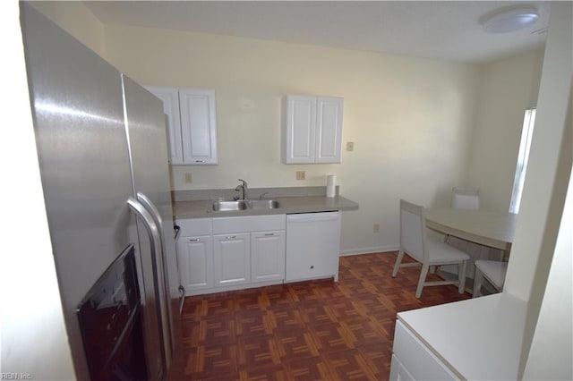 kitchen with stainless steel fridge, sink, white dishwasher, and white cabinets