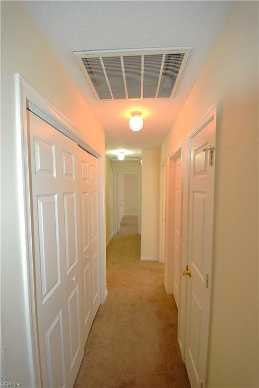 hallway featuring light colored carpet