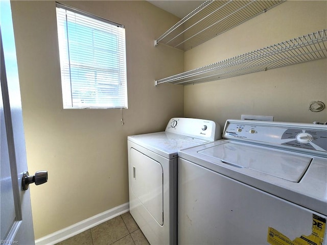 laundry area with light tile patterned floors, separate washer and dryer, and a wealth of natural light