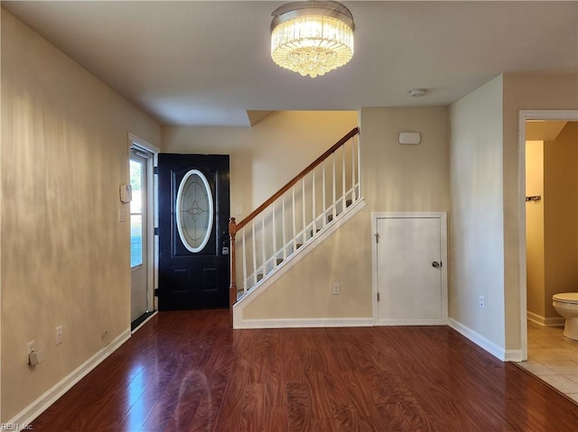 foyer entrance with a notable chandelier and dark wood-type flooring