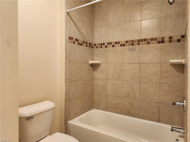 bathroom with toilet and tiled shower / bath