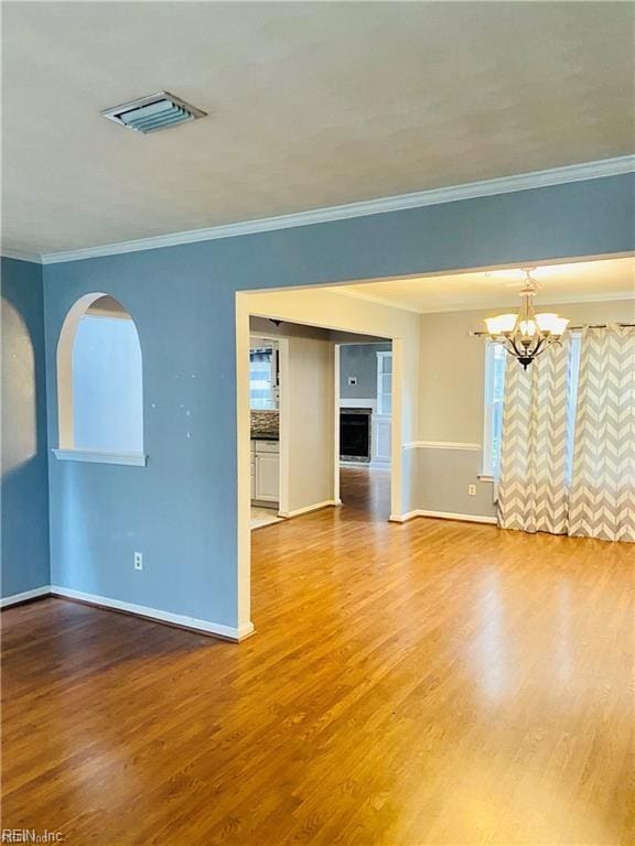 empty room with crown molding and hardwood / wood-style floors