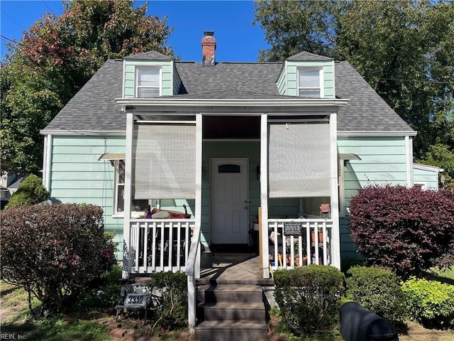 cape cod-style house featuring covered porch