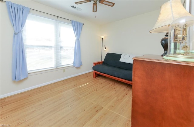 living area featuring wood-type flooring and ceiling fan