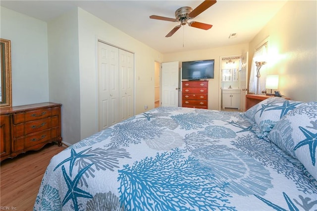 bedroom with ensuite bathroom, ceiling fan, a closet, and hardwood / wood-style floors