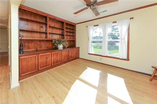 interior space featuring ceiling fan, light wood-type flooring, and crown molding