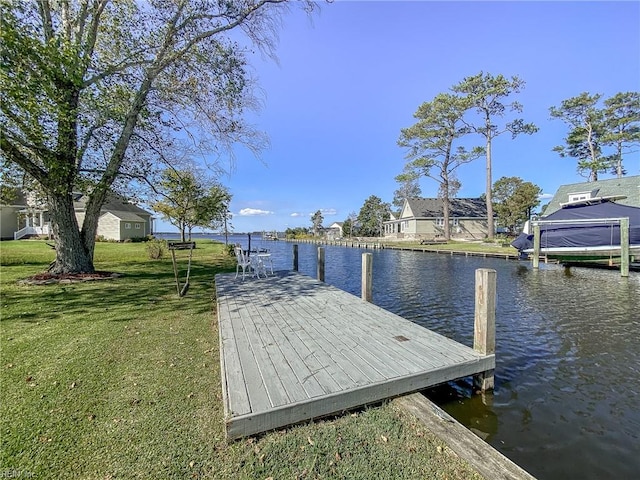 dock area with a water view and a yard