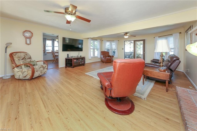 living room with light hardwood / wood-style flooring and ceiling fan