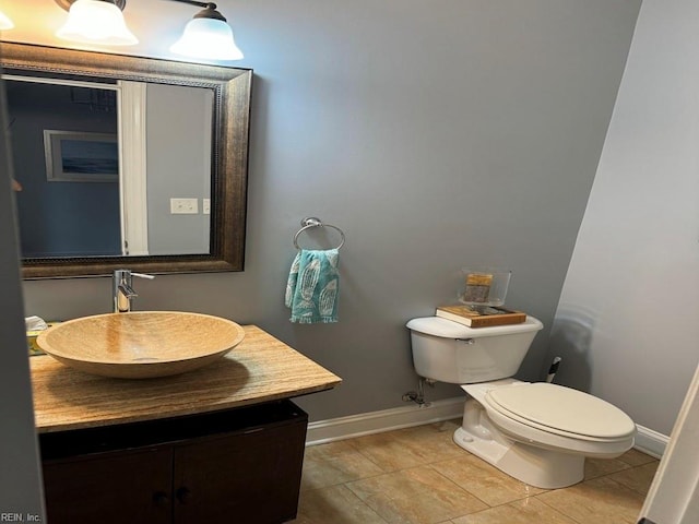 bathroom featuring vanity, tile patterned flooring, and toilet