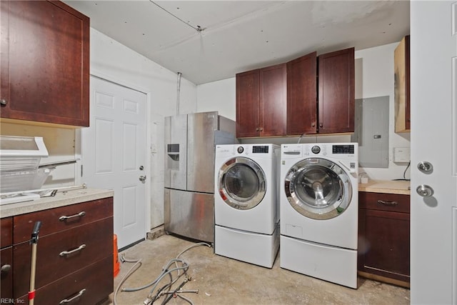 laundry area with electric panel, washer and dryer, and cabinets