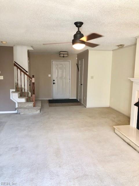 unfurnished living room with carpet floors, a textured ceiling, and ceiling fan