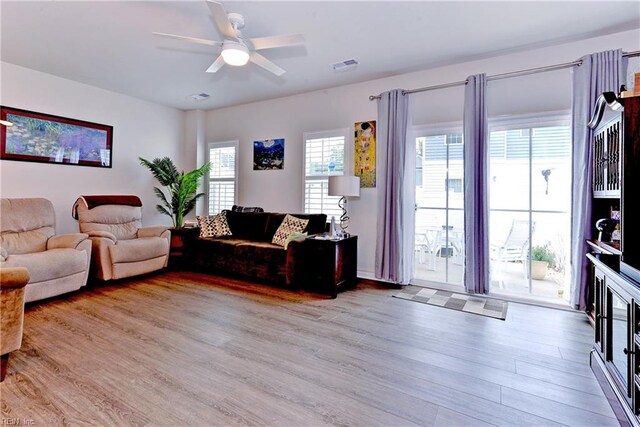 living room featuring ceiling fan and light hardwood / wood-style floors