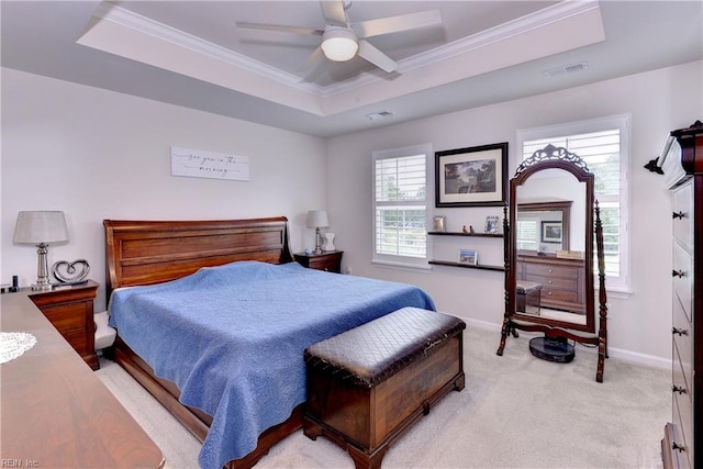 carpeted bedroom with a raised ceiling, ornamental molding, and ceiling fan