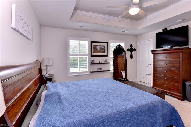 carpeted bedroom featuring ceiling fan, a tray ceiling, and ornamental molding