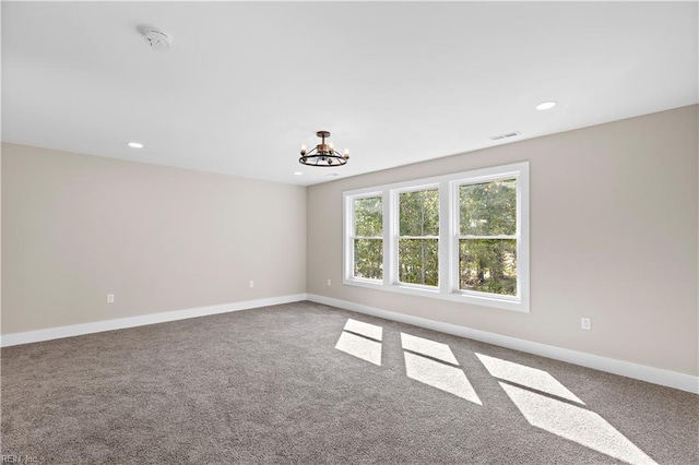 unfurnished room featuring carpet flooring and a notable chandelier