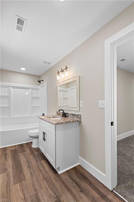 full bathroom featuring vanity, wood-type flooring, bathtub / shower combination, and toilet