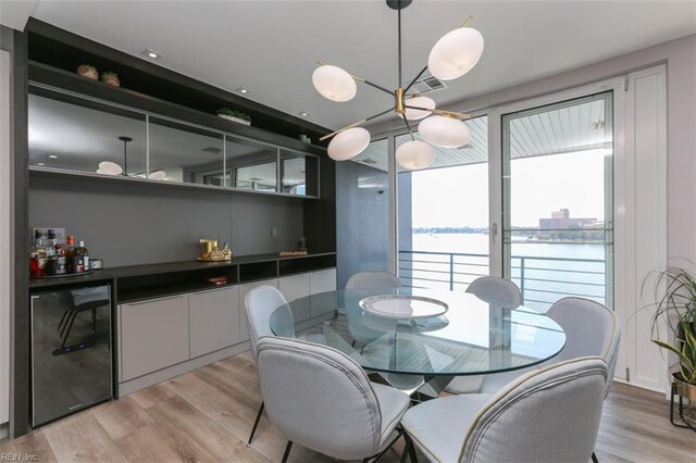 dining area featuring light hardwood / wood-style flooring and a water view