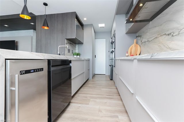 kitchen featuring hanging light fixtures, light hardwood / wood-style floors, and tasteful backsplash