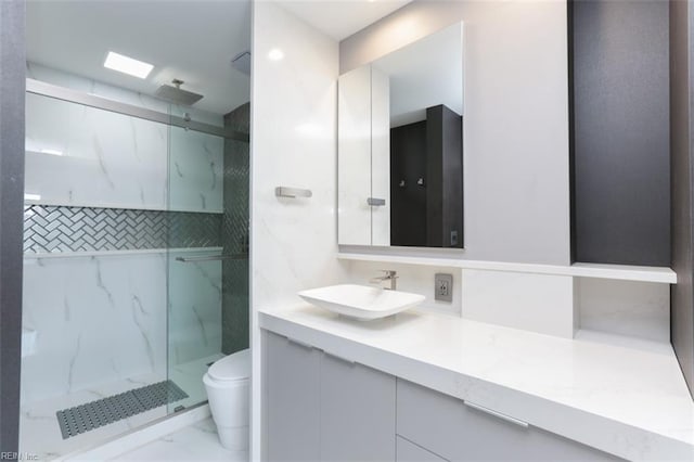 bathroom featuring tiled shower, vanity, and toilet