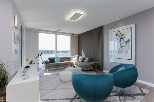 living room with light hardwood / wood-style flooring and a water view