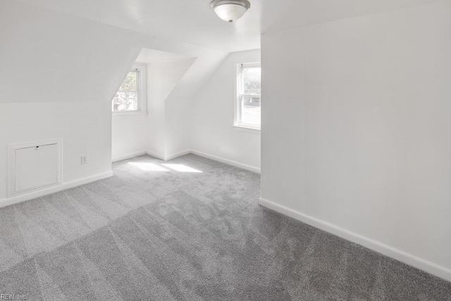 additional living space featuring lofted ceiling and carpet flooring