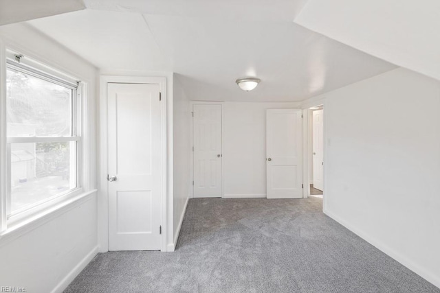 interior space featuring carpet flooring and vaulted ceiling