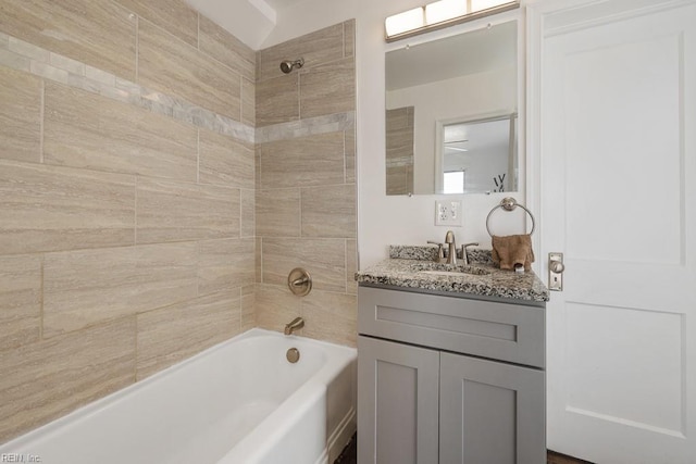 bathroom with tiled shower / bath and vanity