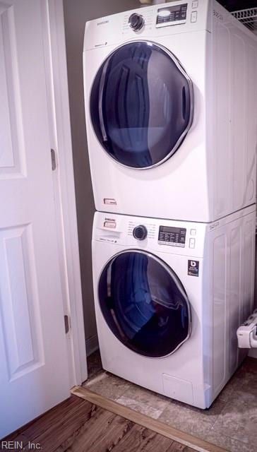 laundry area featuring hardwood / wood-style floors and stacked washer / drying machine