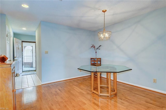 dining area with an inviting chandelier and light wood-type flooring