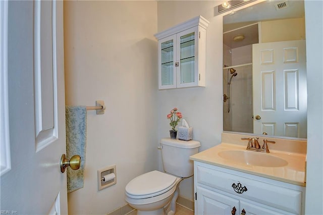 bathroom with a tile shower, vanity, tile patterned flooring, and toilet