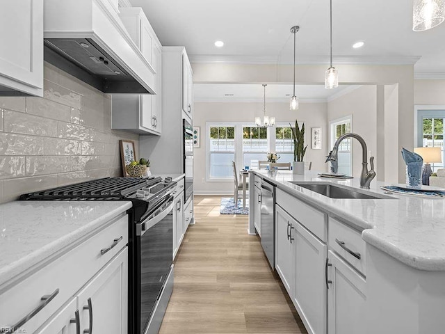 kitchen with appliances with stainless steel finishes, white cabinets, sink, and custom range hood