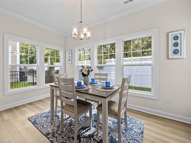 dining space featuring a chandelier, crown molding, and light hardwood / wood-style flooring