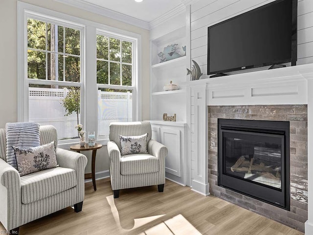 living area featuring ornamental molding, built in features, and light hardwood / wood-style floors