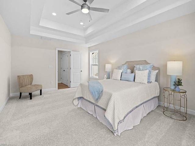 bedroom with carpet floors, a tray ceiling, and ceiling fan