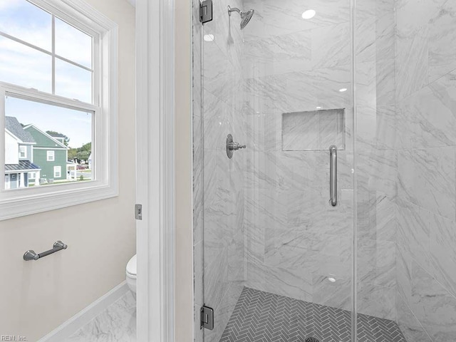 bathroom with an enclosed shower and toilet