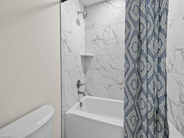 bathroom featuring shower / tub combo and toilet