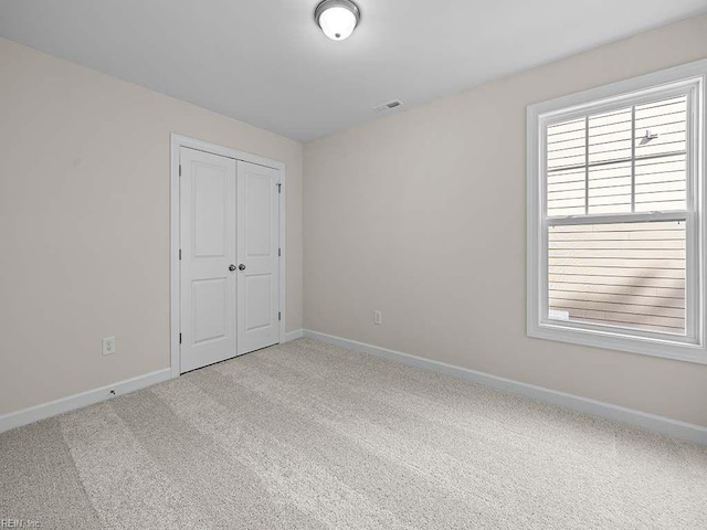 unfurnished bedroom featuring a closet, carpet, and multiple windows