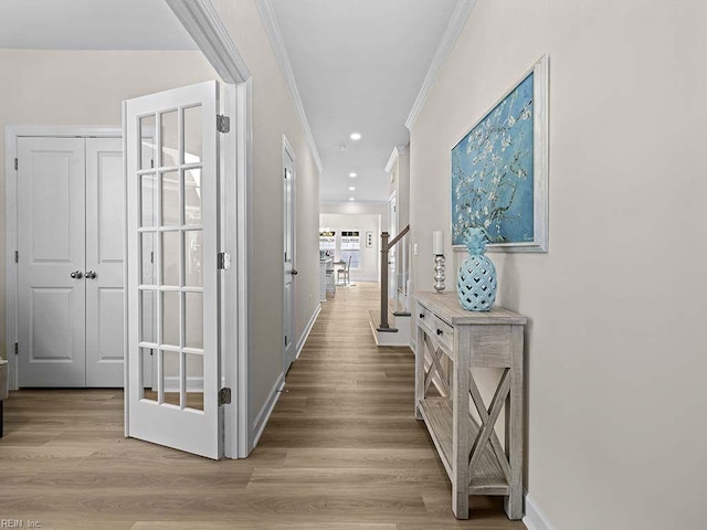 corridor featuring ornamental molding and light hardwood / wood-style flooring