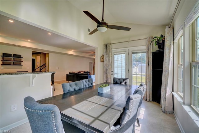 dining area with ceiling fan and high vaulted ceiling