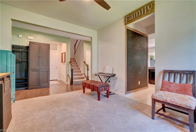 interior space with ceiling fan and light carpet