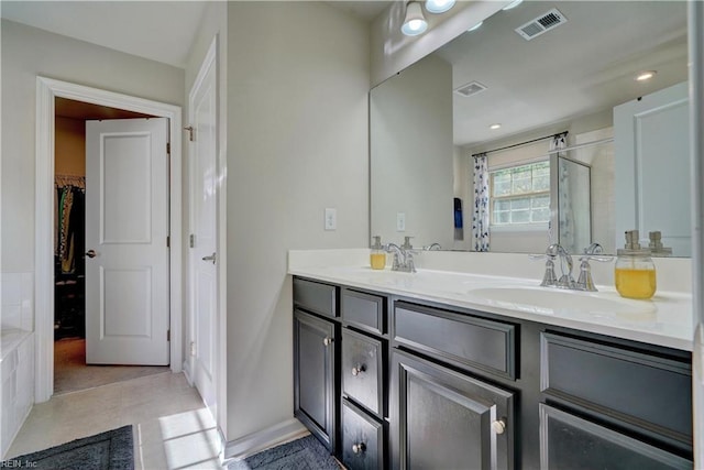 bathroom featuring tile patterned floors, walk in shower, and vanity