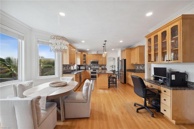 dining space with a chandelier, crown molding, light hardwood / wood-style flooring, and sink